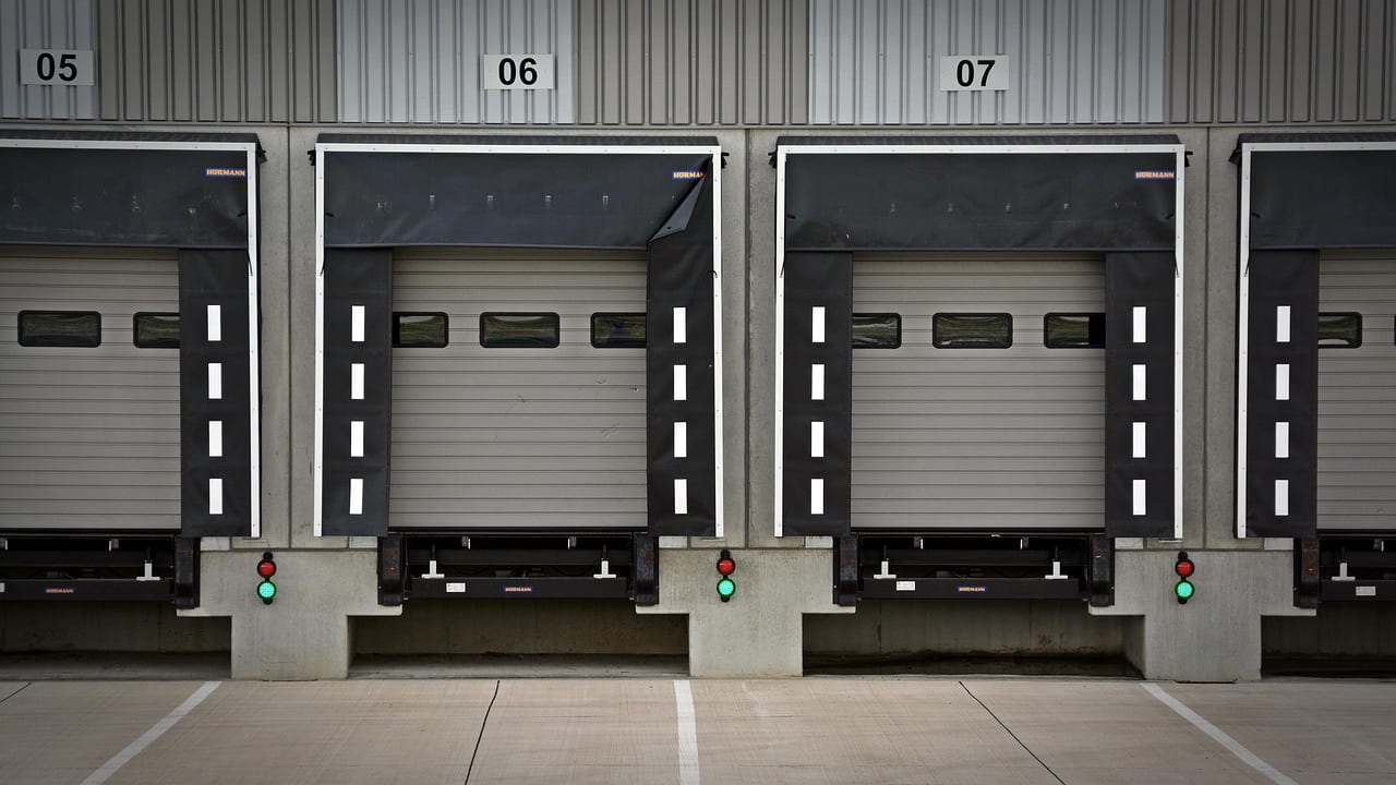 Numbered loading dock doors with dock levelers and red and green signal lights