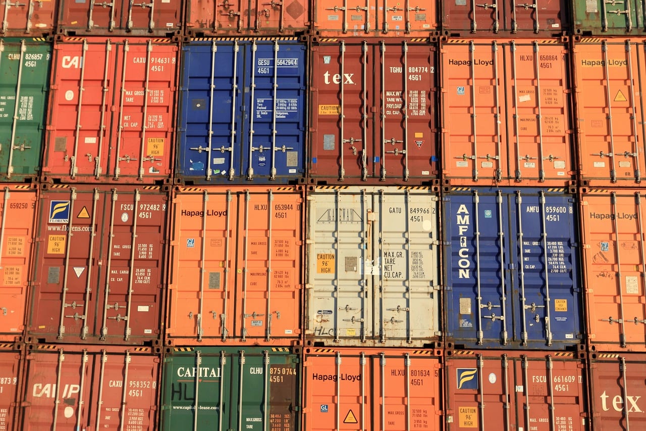 Stacked shipping containers filling the frame, orange with a few in blue and white