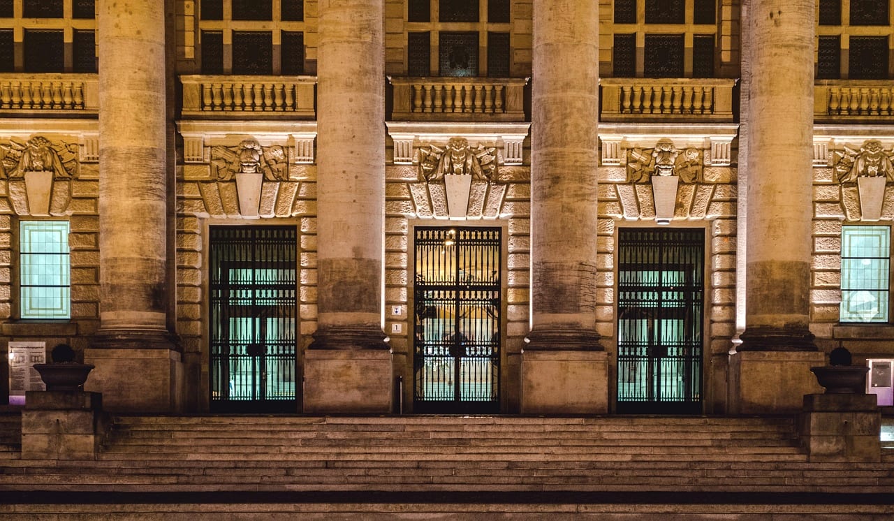 The columned entrance of a courthouse lit at night