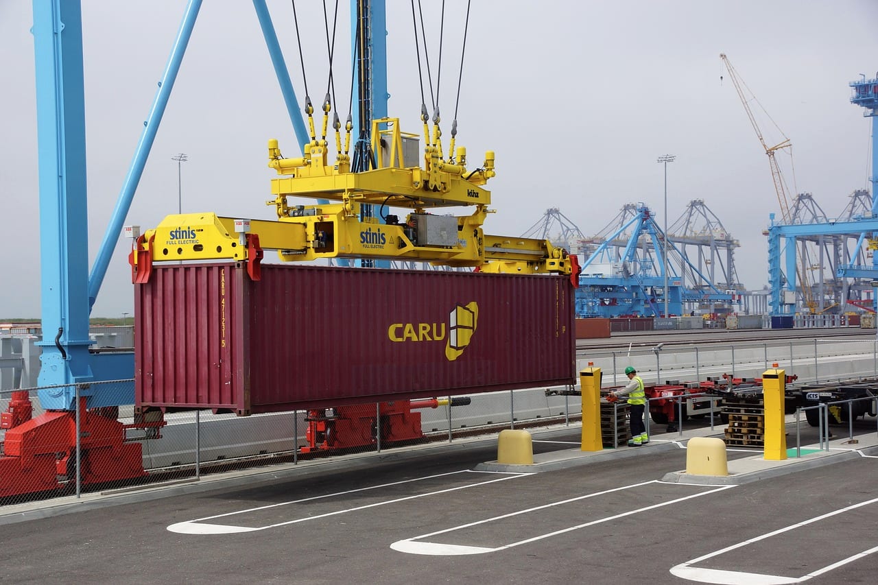 A crane spreader lowering a container onto a quay