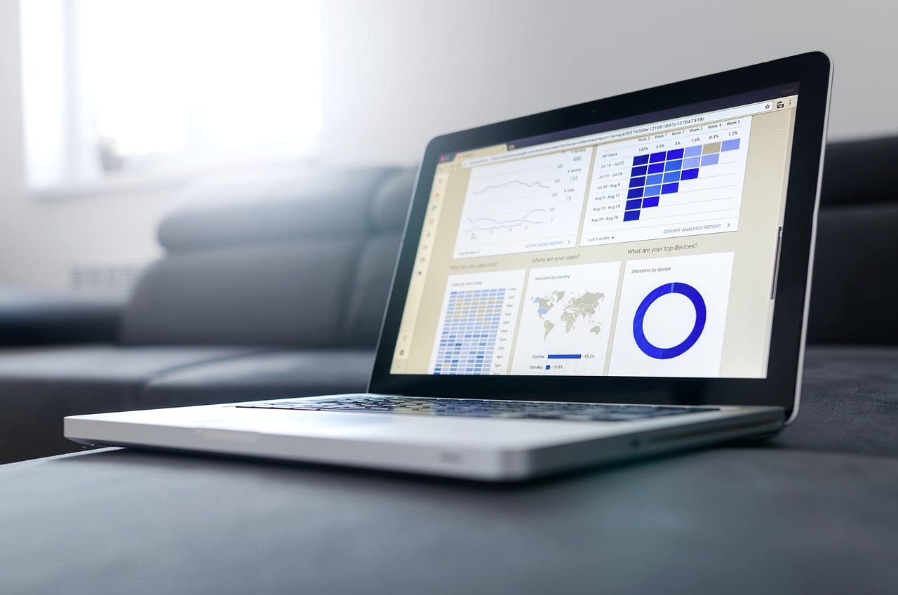 A laptop open on charts and a map