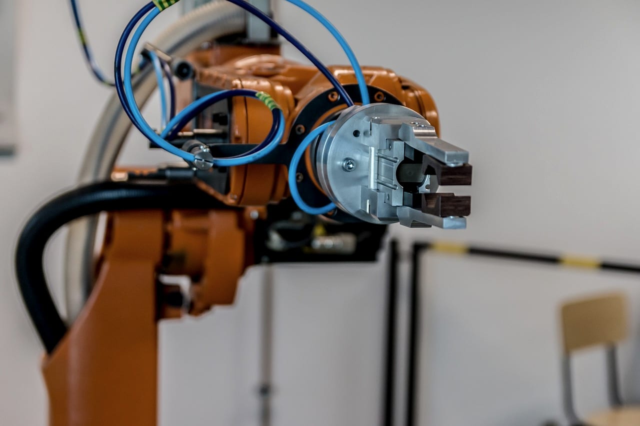An orange industrial robot arm with its gripper raised