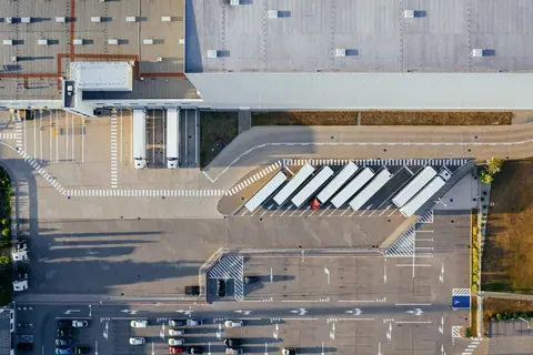 A freight depot from the air, white trailers parked in a fan beside the building